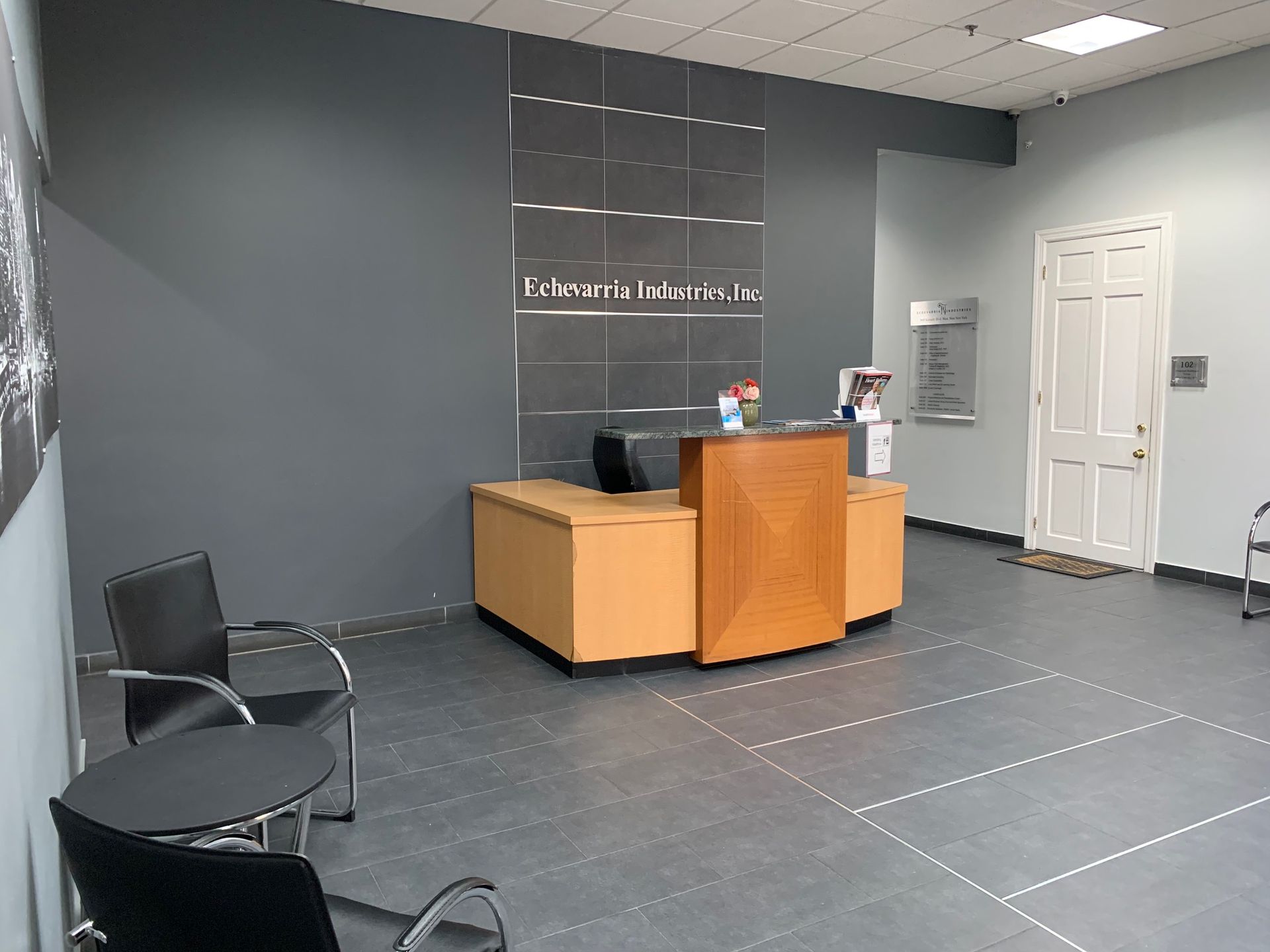 A reception area with a desk , chairs and a table.