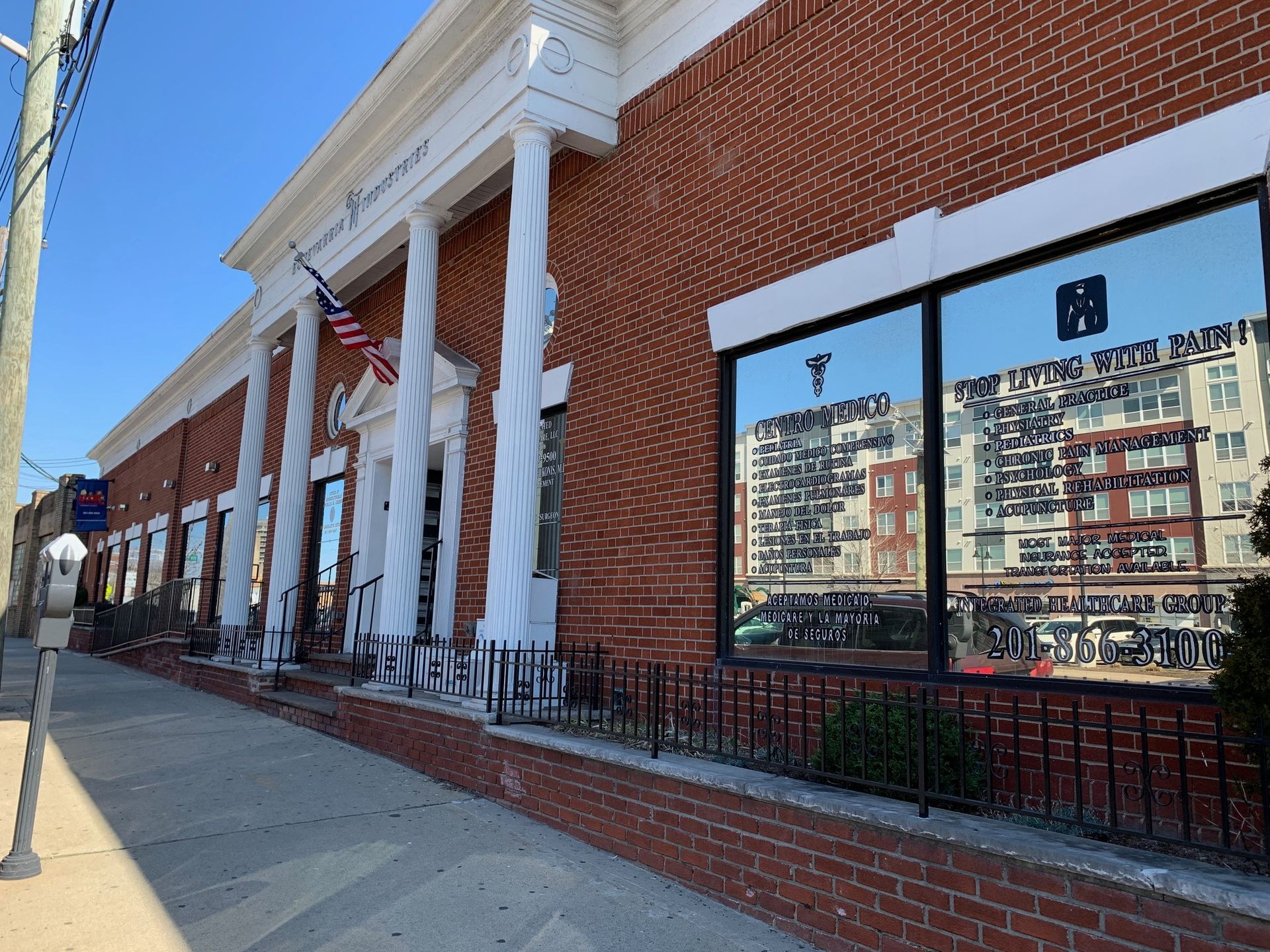 A large brick building with a reflection of a city in the windows