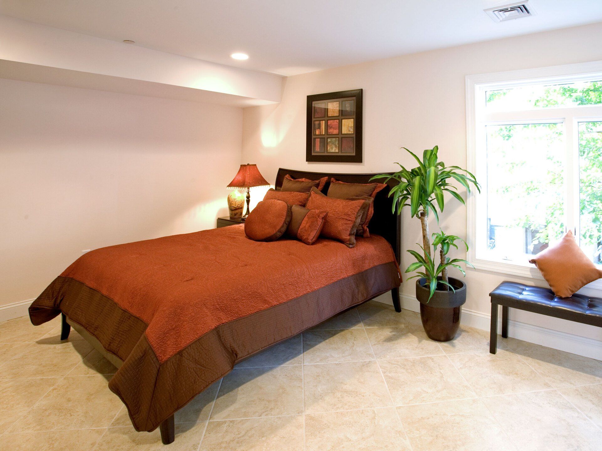 A bedroom with a large bed and a potted plant