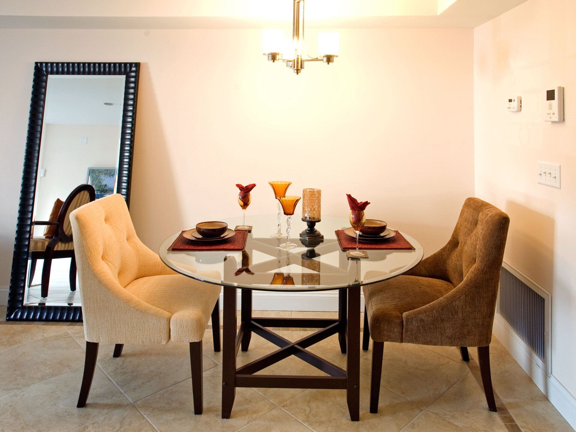 A dining room with a round glass table and chairs