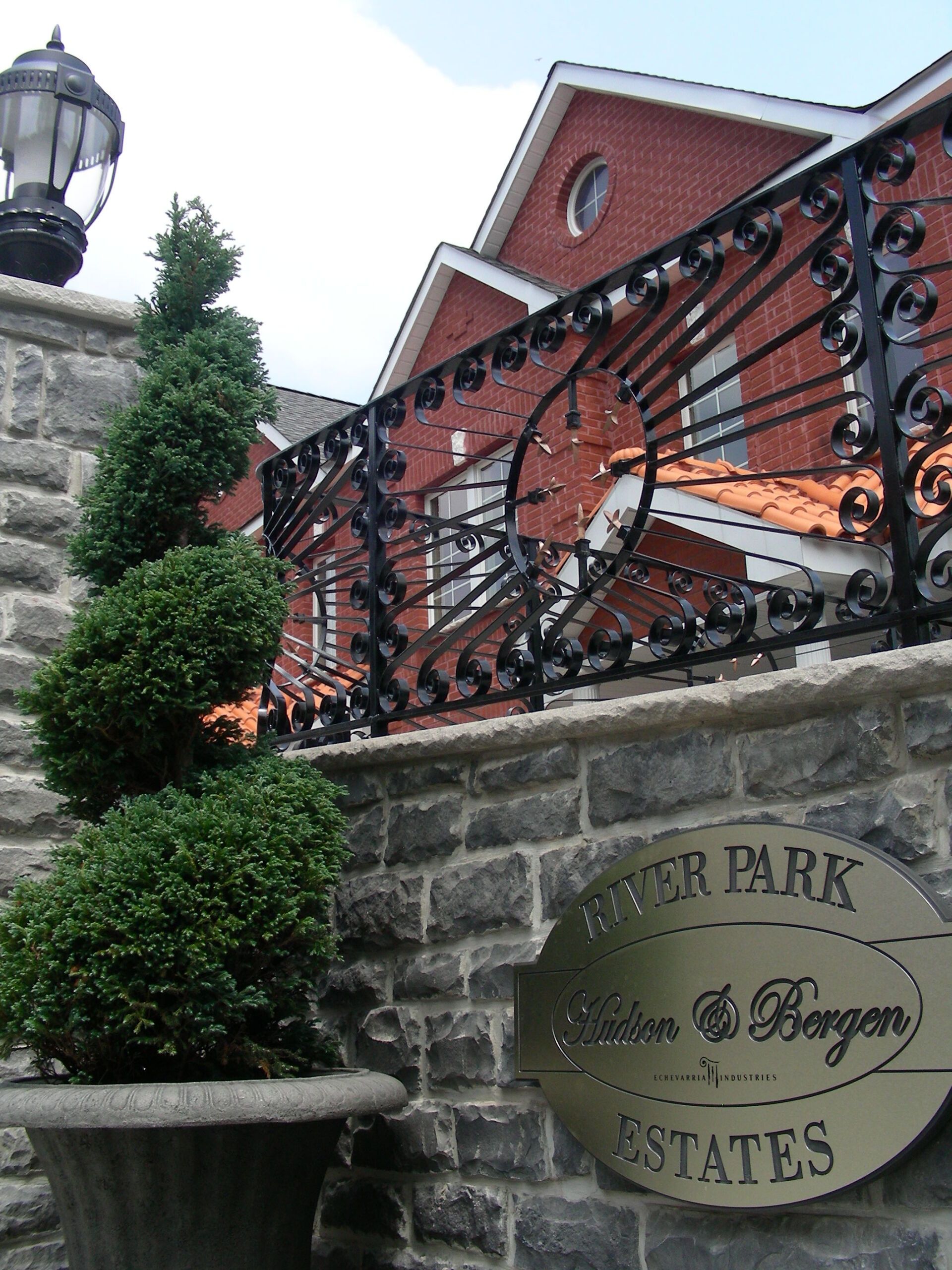 A sign on a stone wall says river park estates