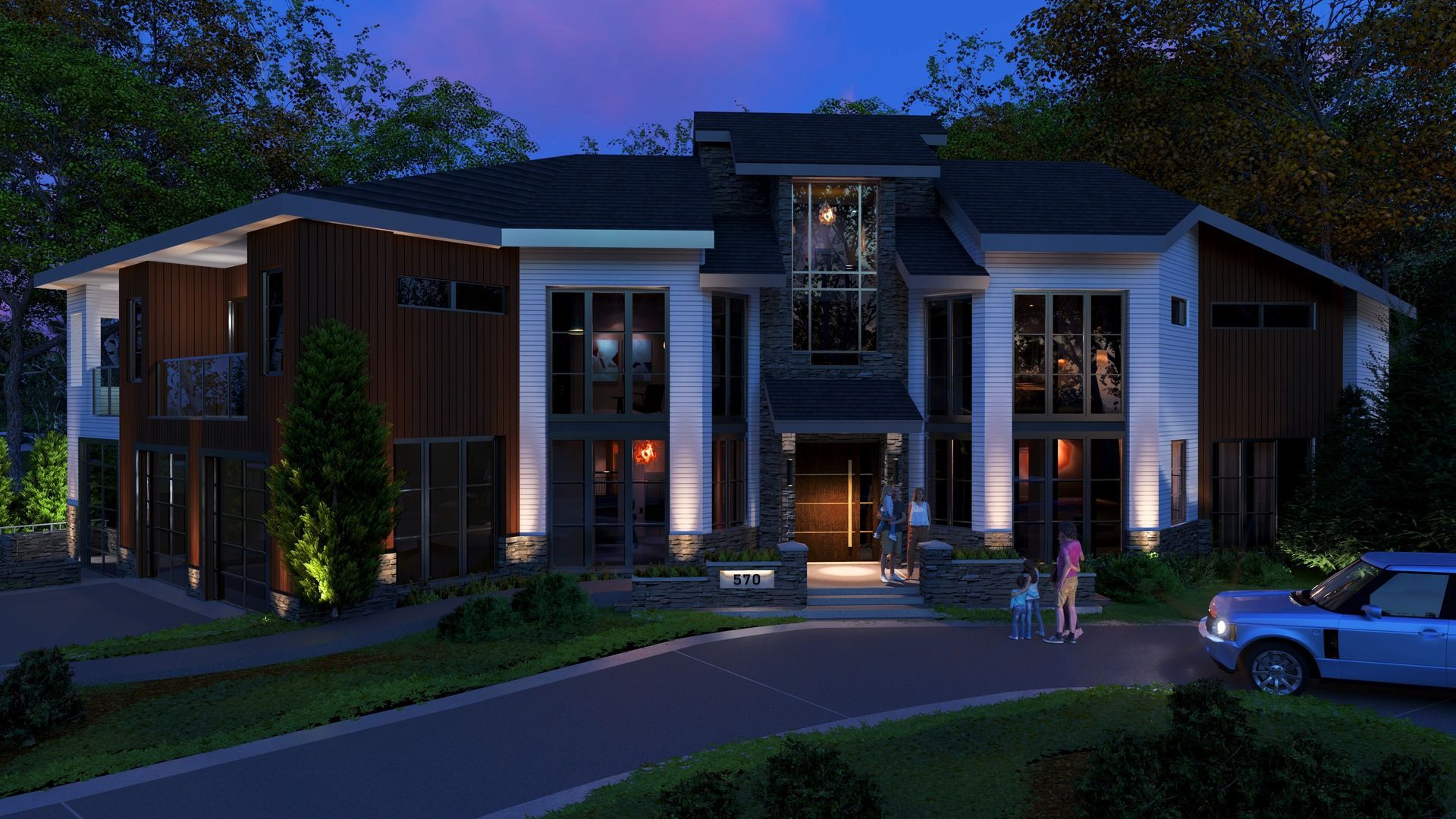 A large house is lit up at night with a car parked in front of it.