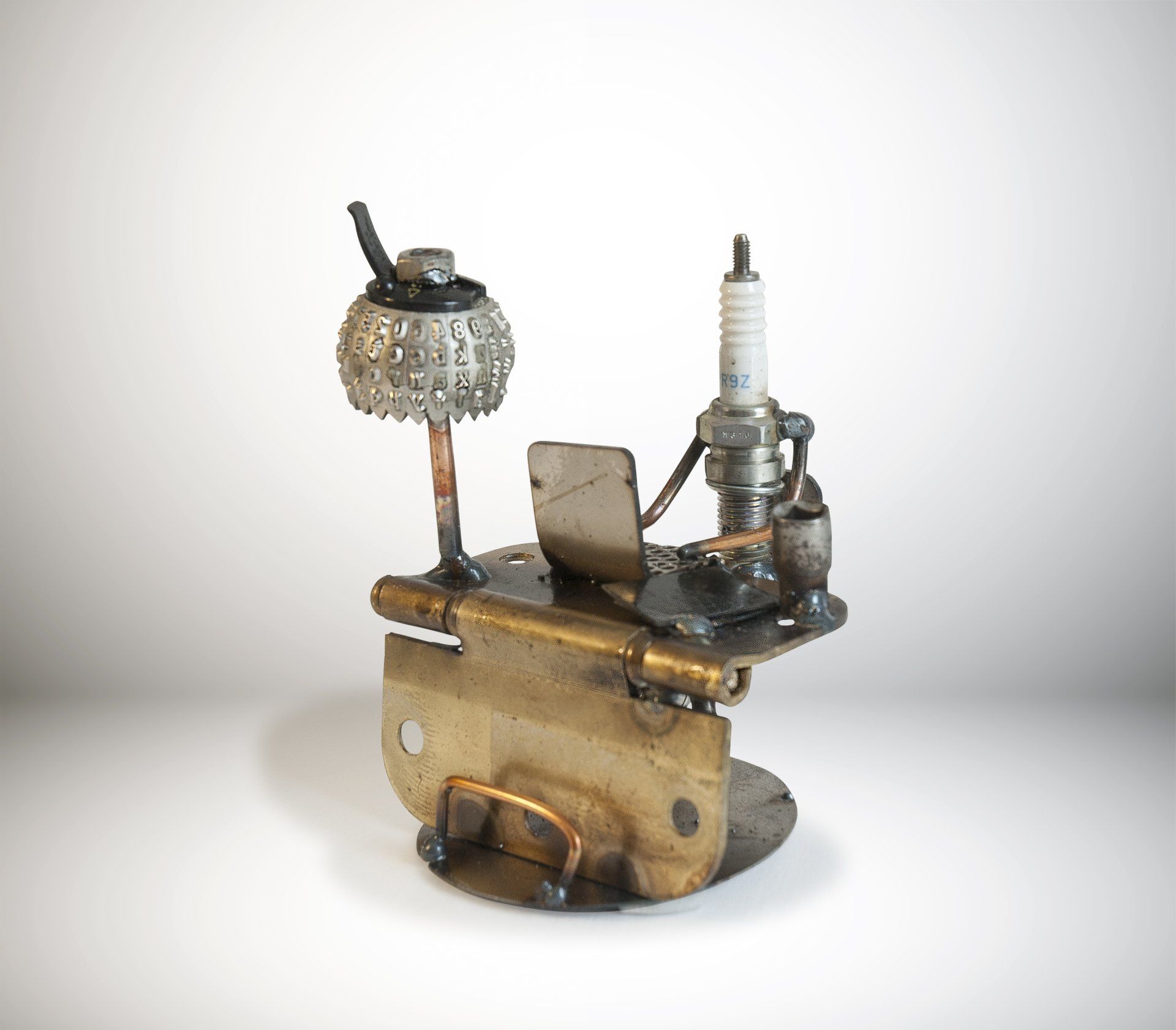 Sparkplug Sculpture of Figurine at desk with laptop and lamp