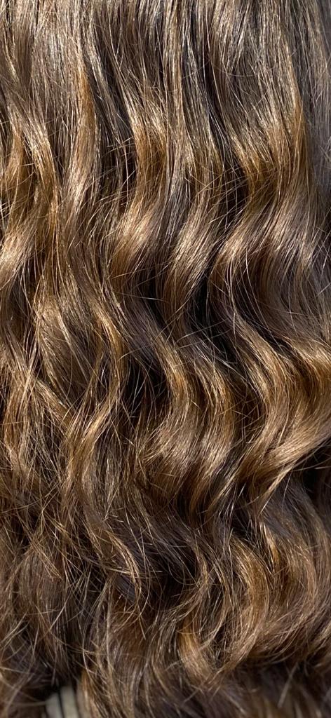 Primo piano di capelli ricci, castani e castano scuro.
