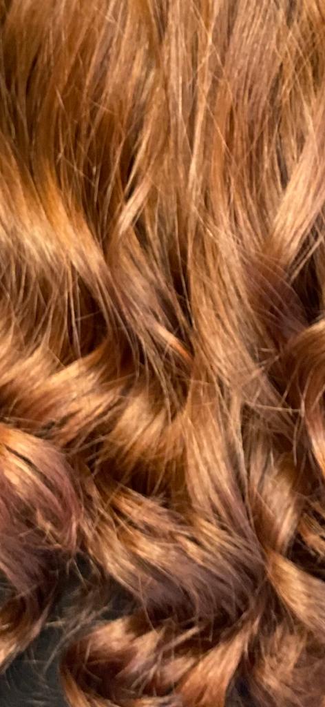 Primo piano di capelli ondulati color castano-rossiccio.