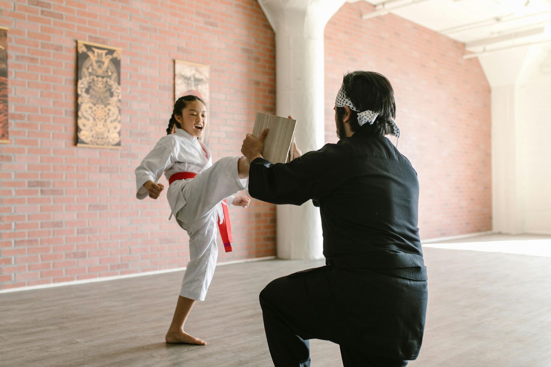 girl breaking board with martial arts kick