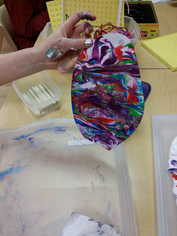 A person is holding a piece of paper with a colorful design on it.