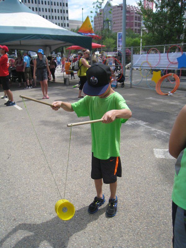 A boy in a green shirt is playing with a yellow object