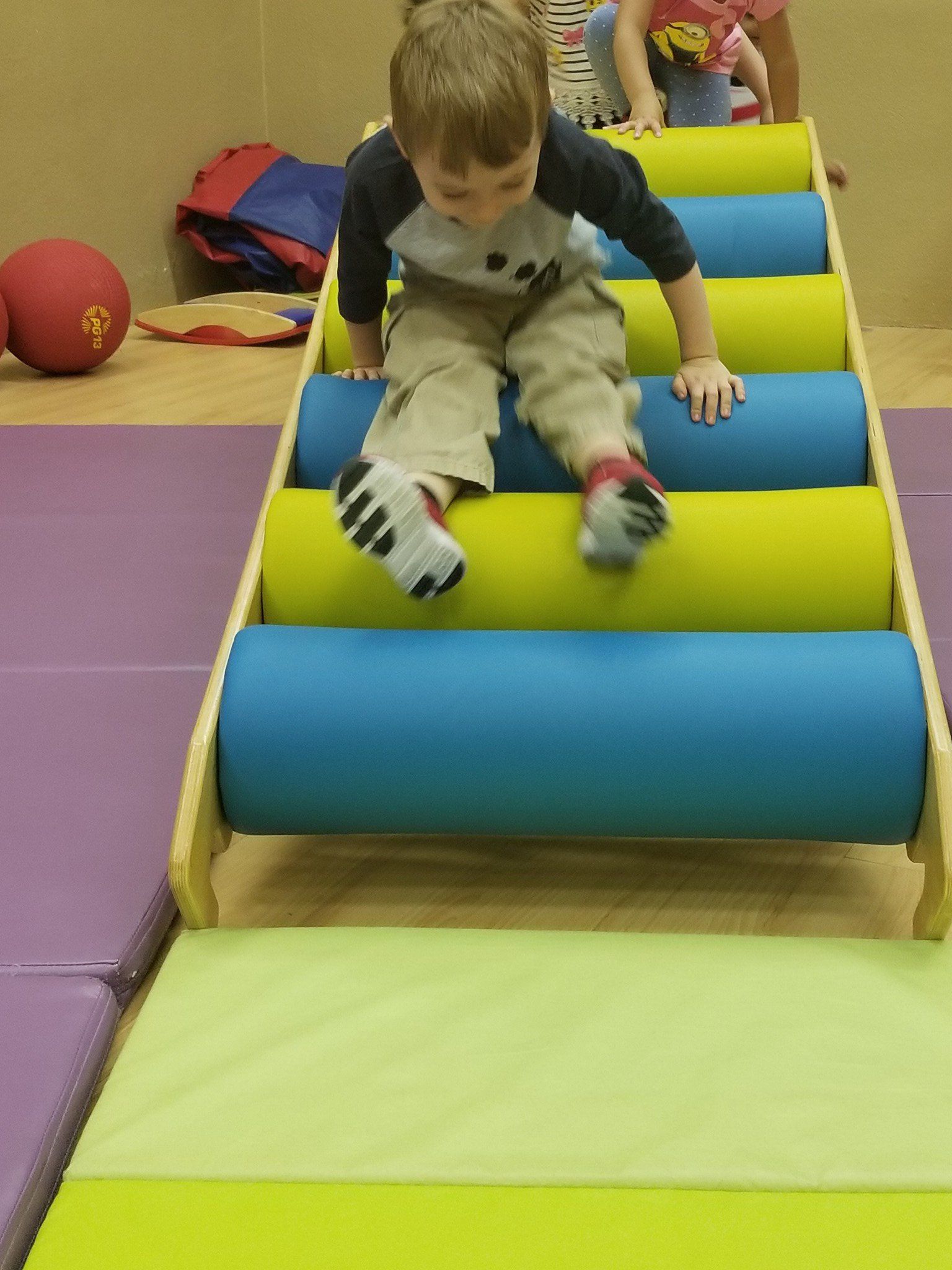 A young boy is sitting on a blue and yellow roller coaster