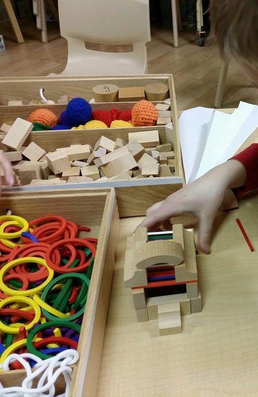 A child is playing with wooden blocks on a table.