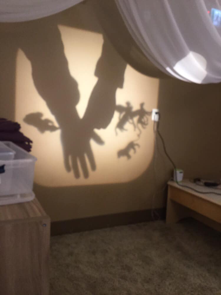 A shadow of a person holding hands is projected on a wall