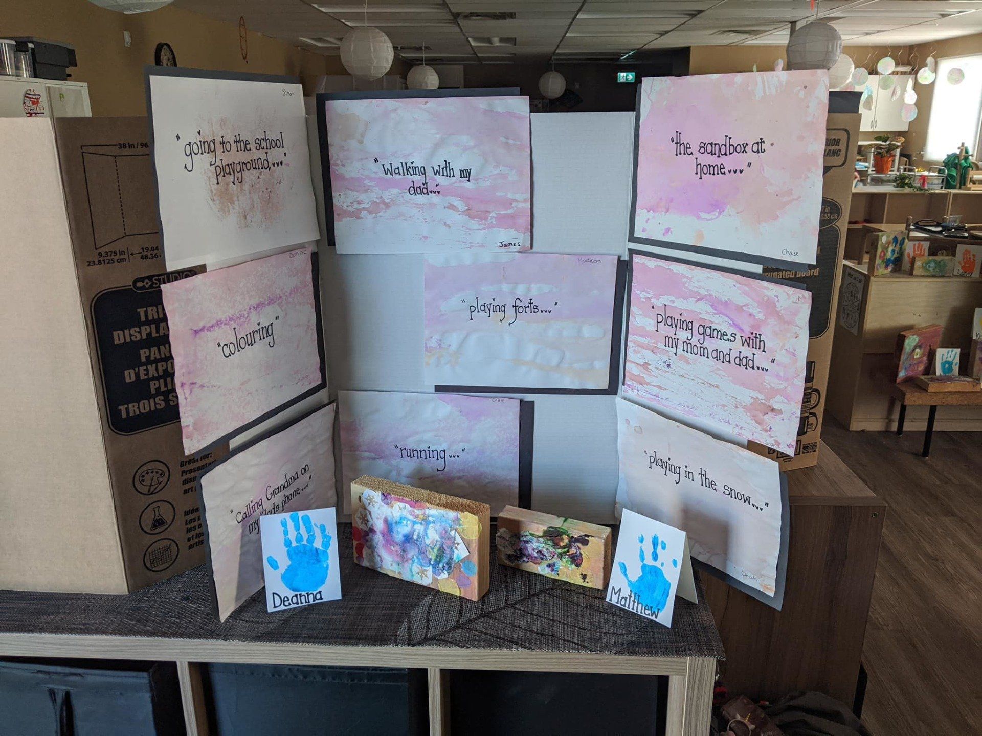 A display of children 's artwork is sitting on a table in a room.