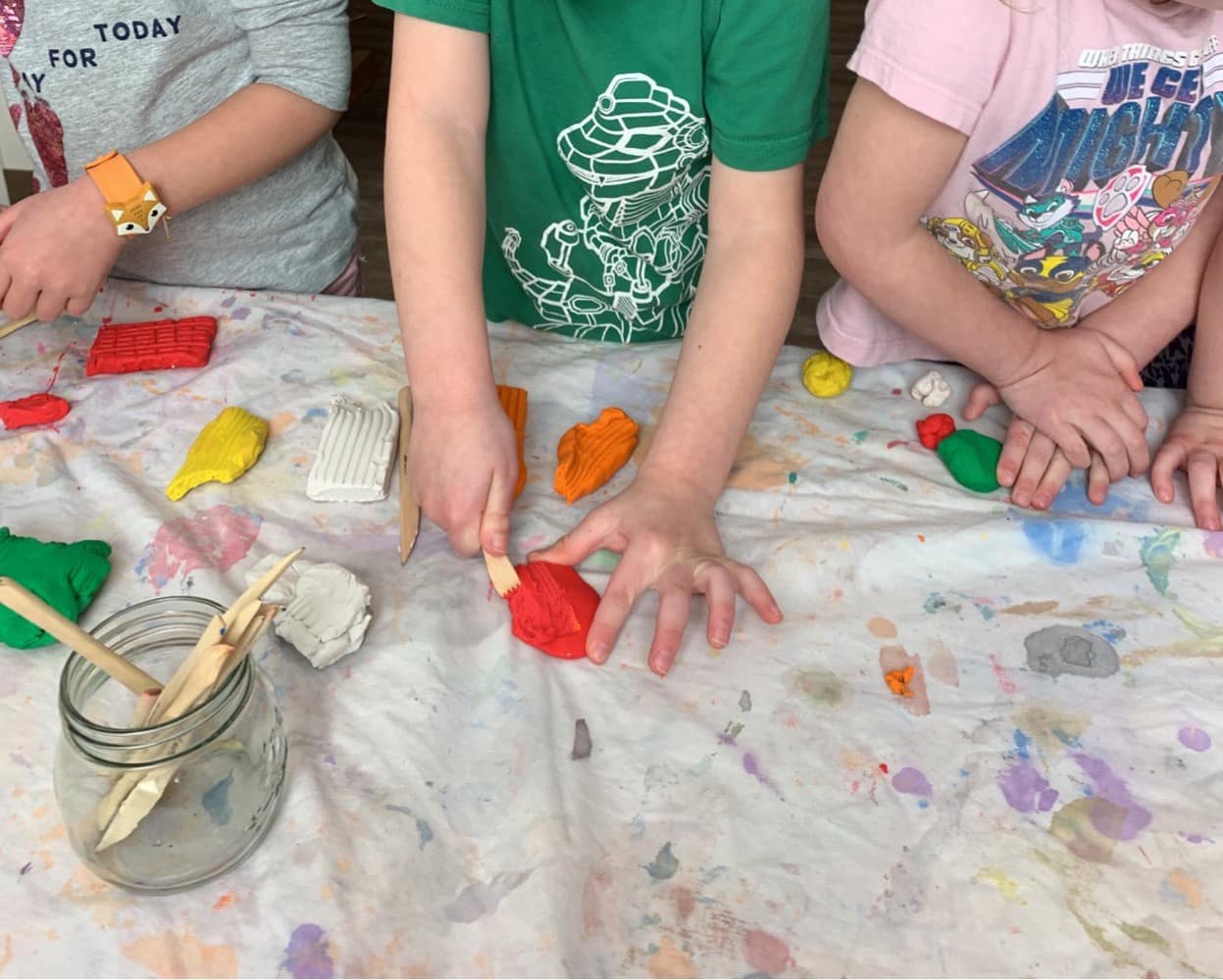 A group of children are playing with play dough on a table.