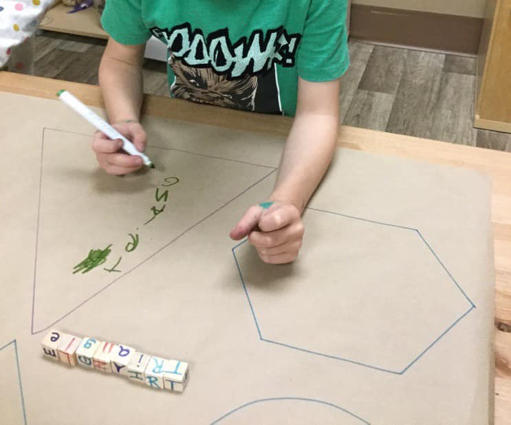 A child wearing a green shirt with the word down on it