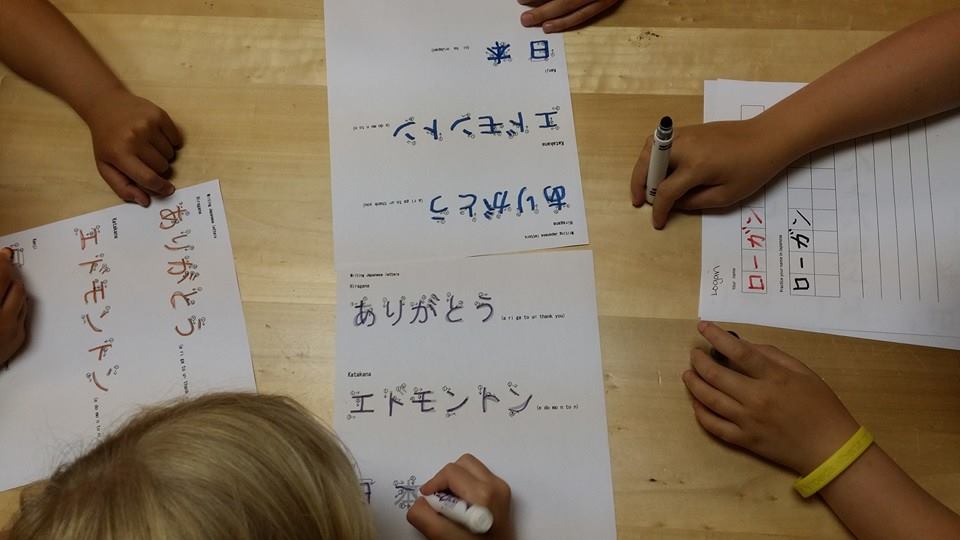 A group of people are writing on a piece of paper