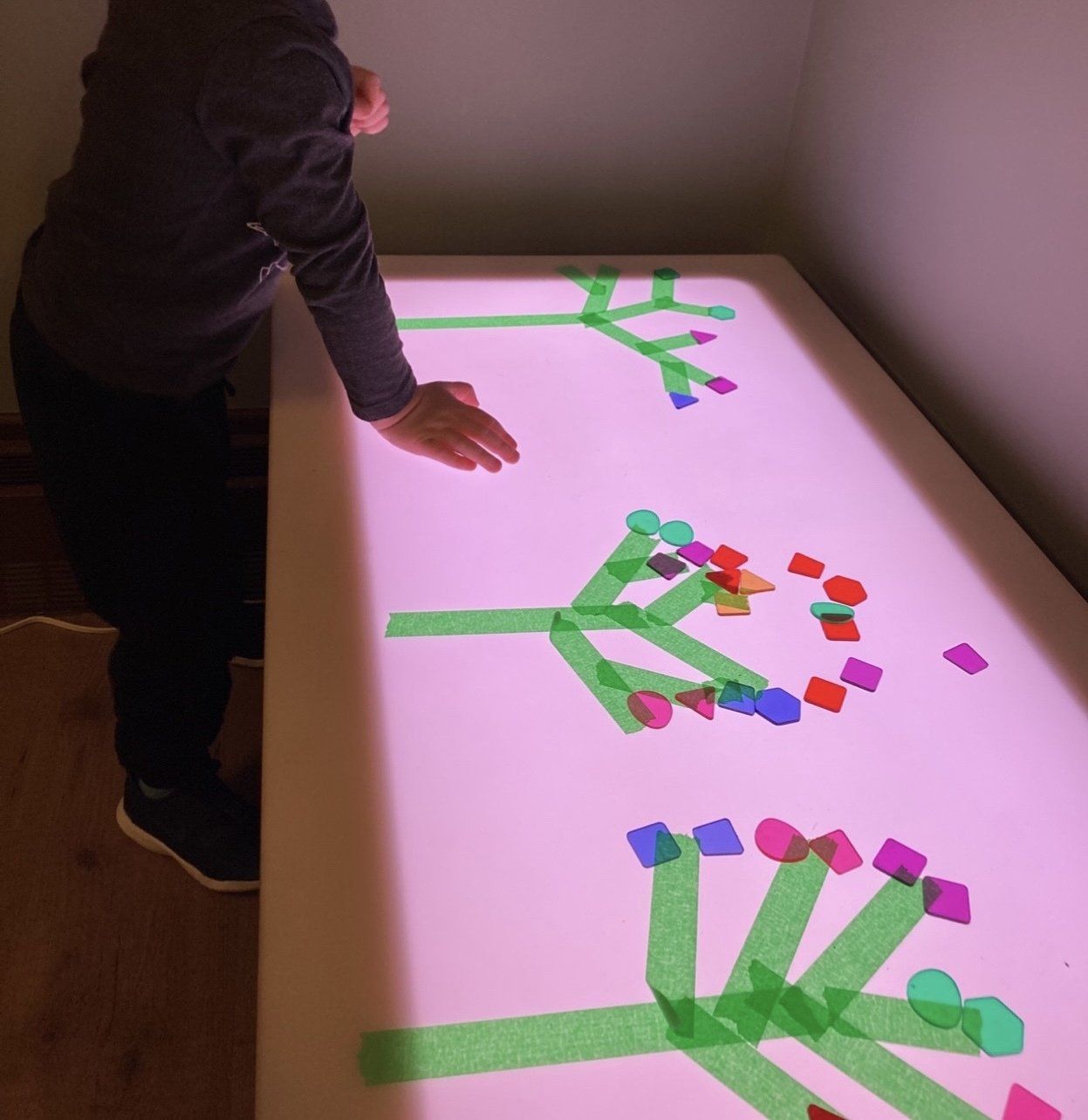 A child is playing with tape on a table
