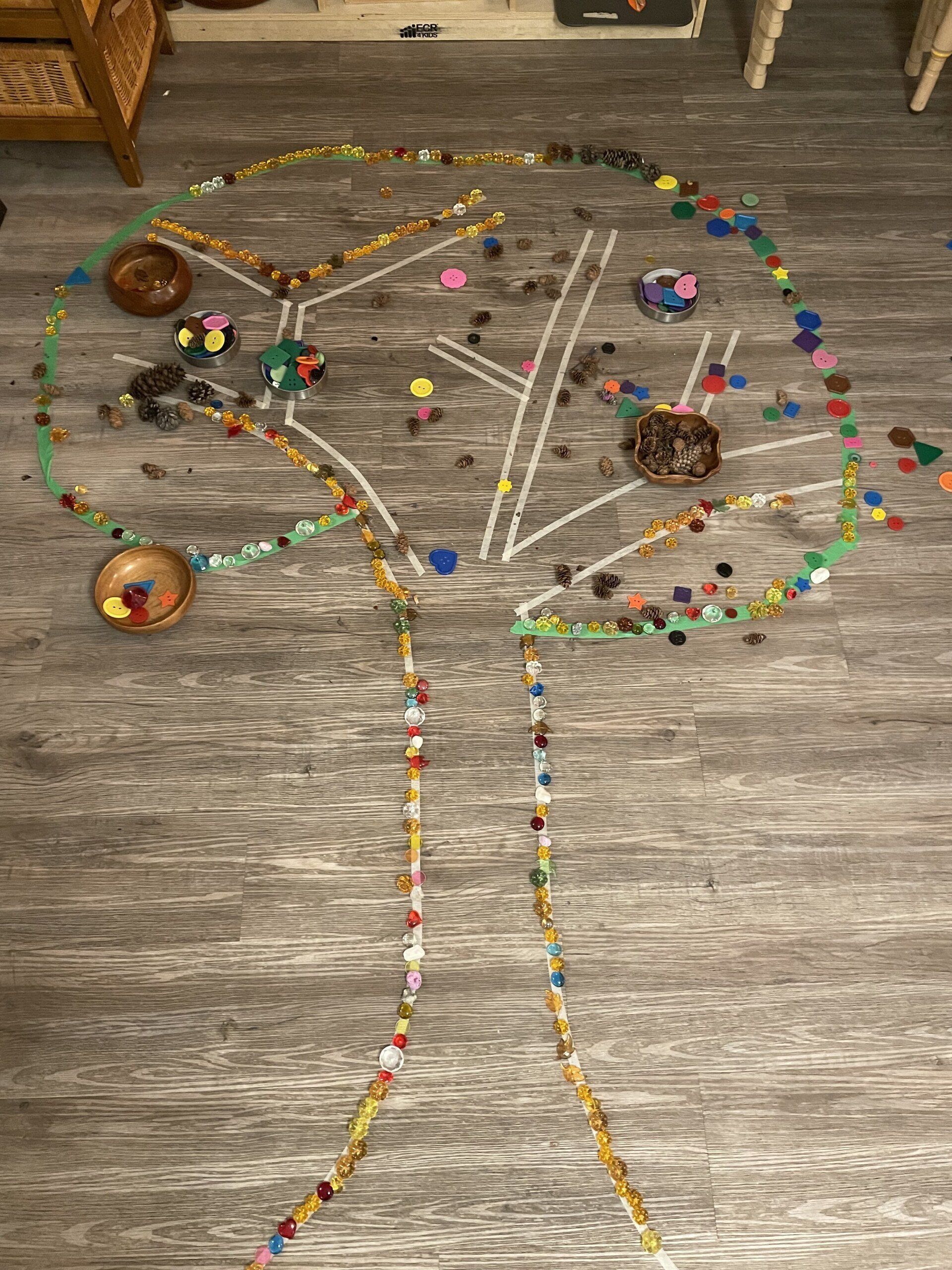 A tree made of beads is sitting on a wooden floor.