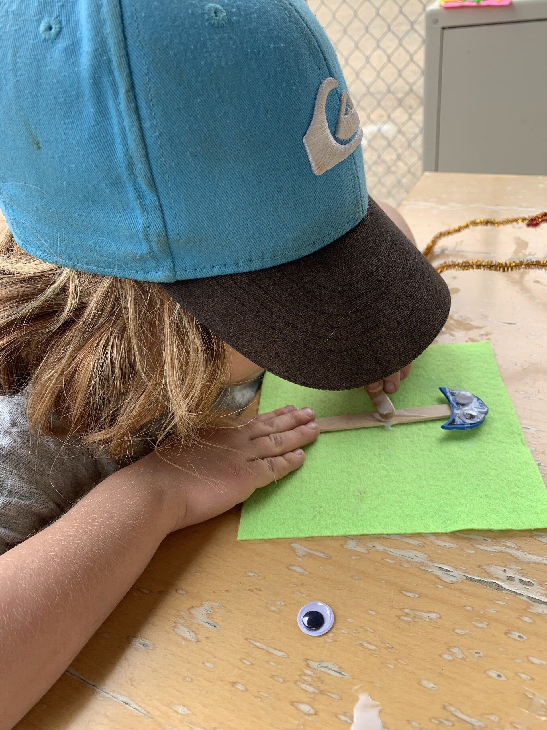 A person wearing a blue hat is sitting at a table.