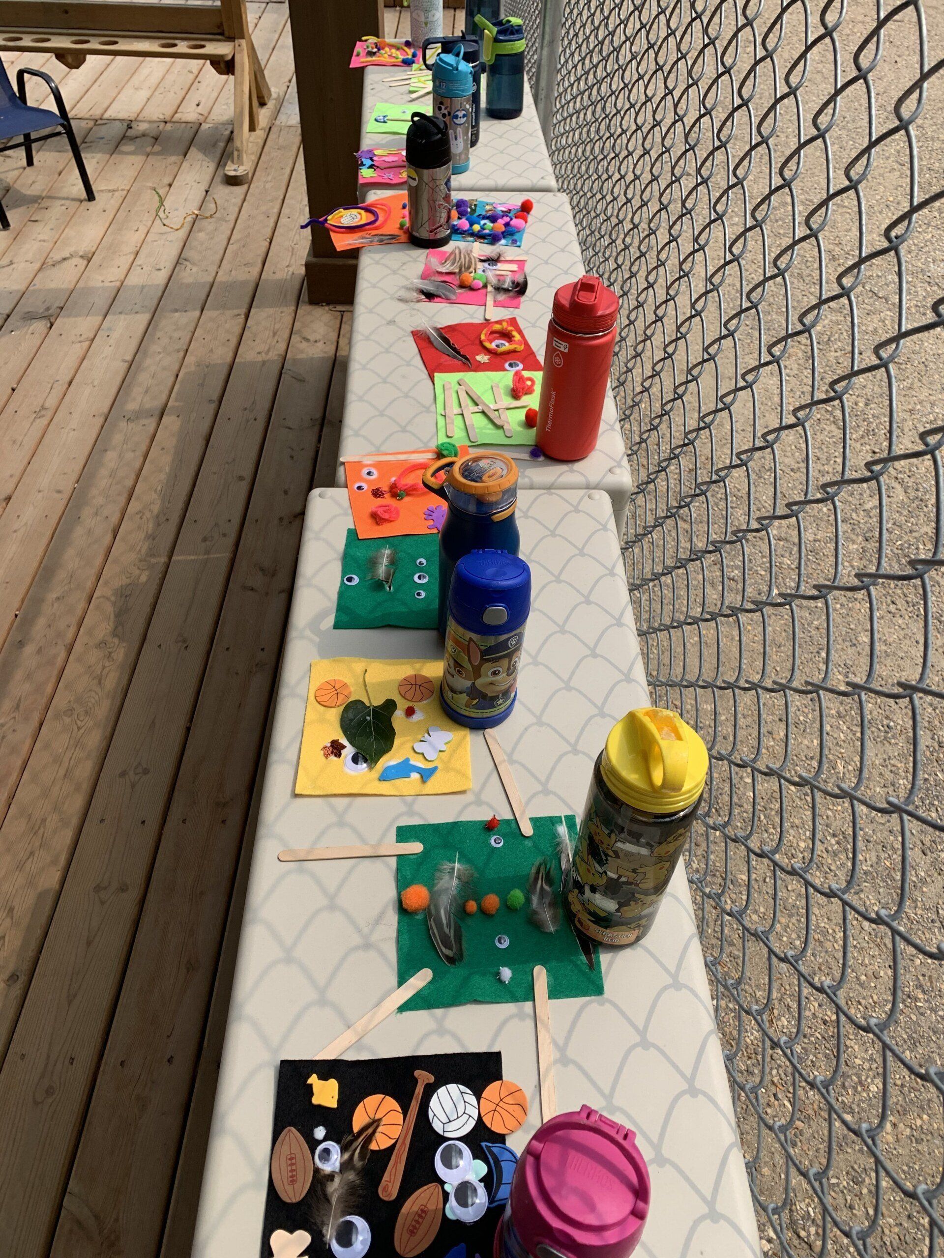 A row of tables with crafts and water bottles on them