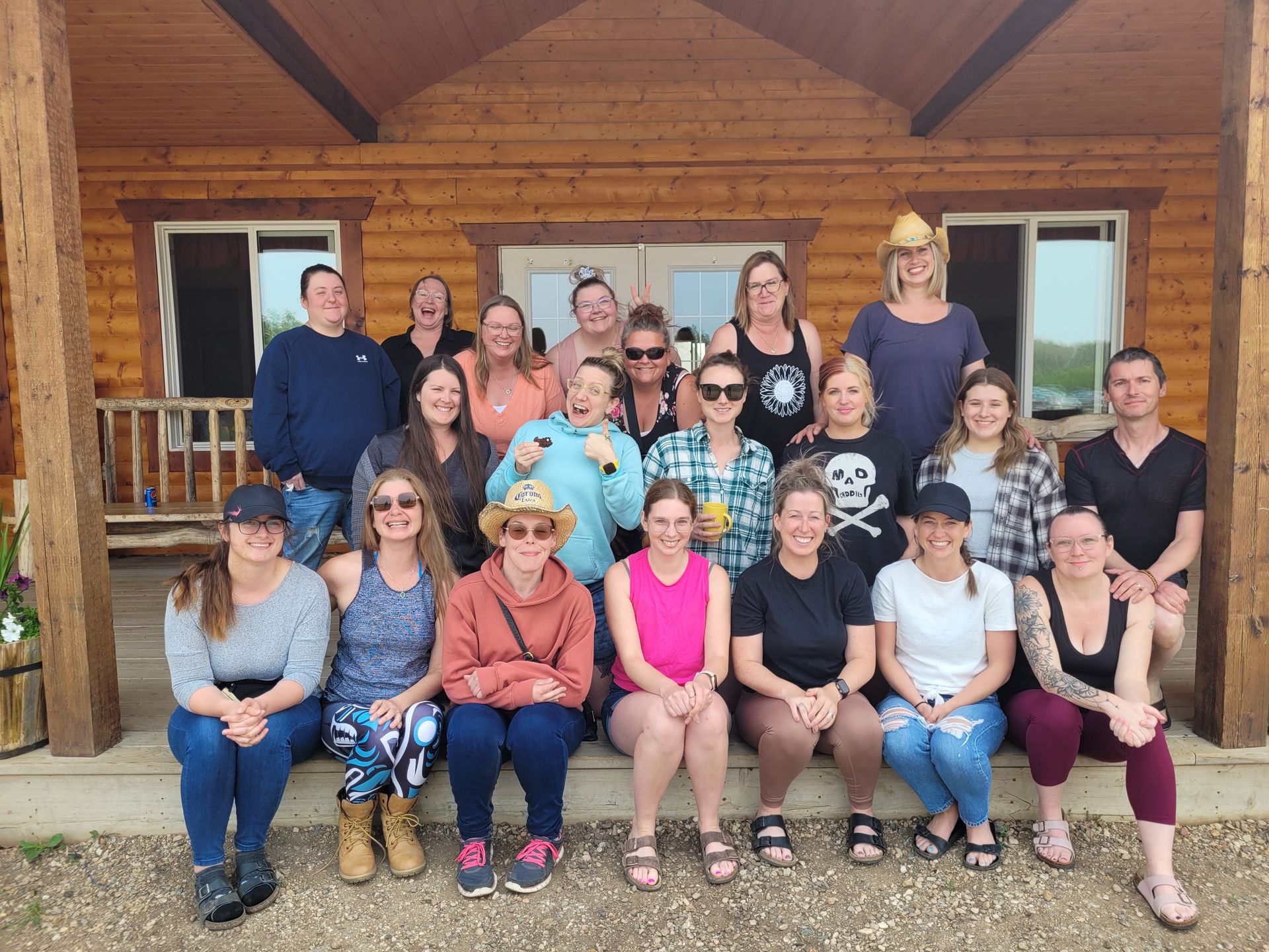 A group of people are posing for a picture in front of a log cabin.