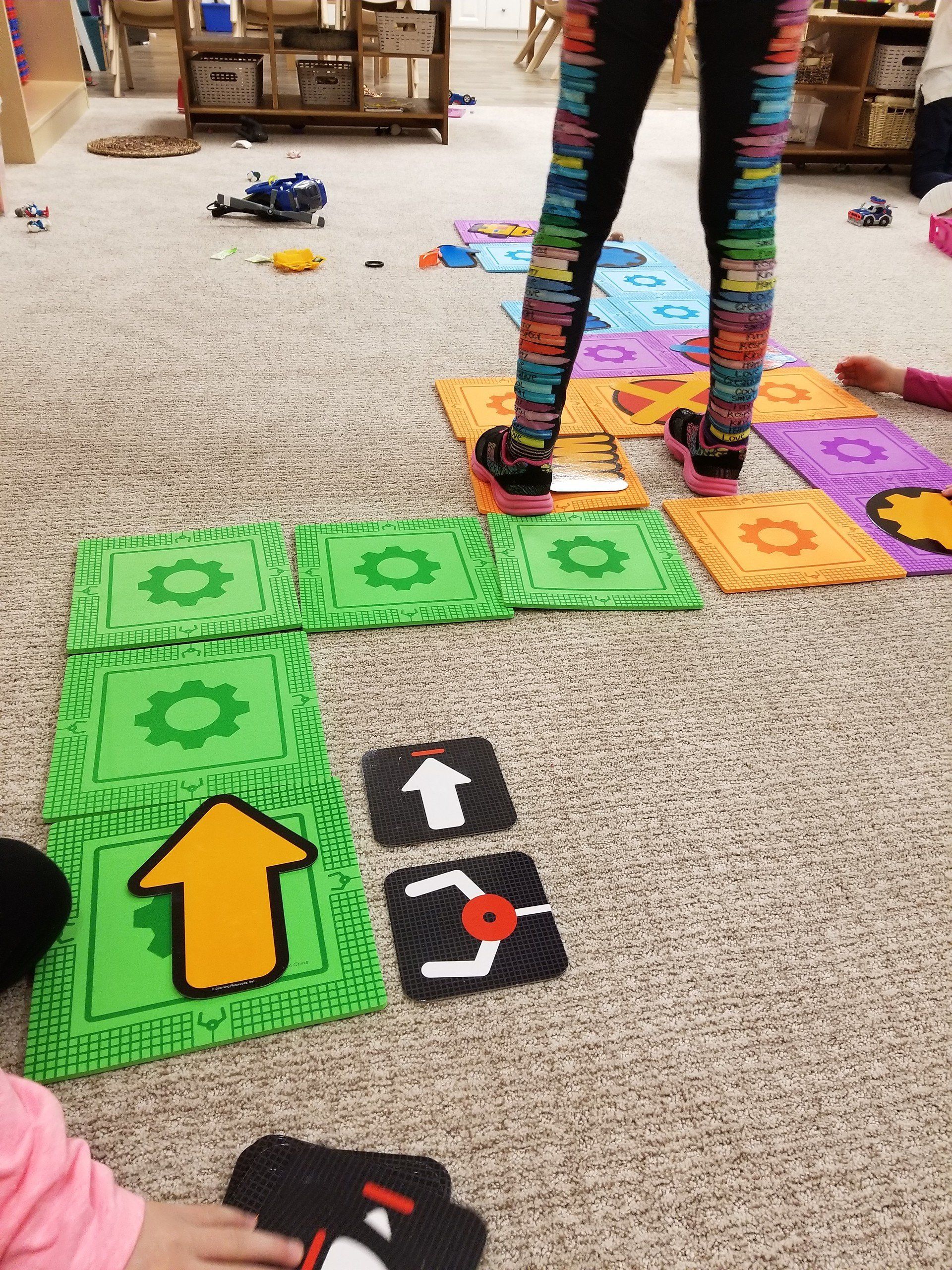 A group of children are playing a game of dominoes on the floor.