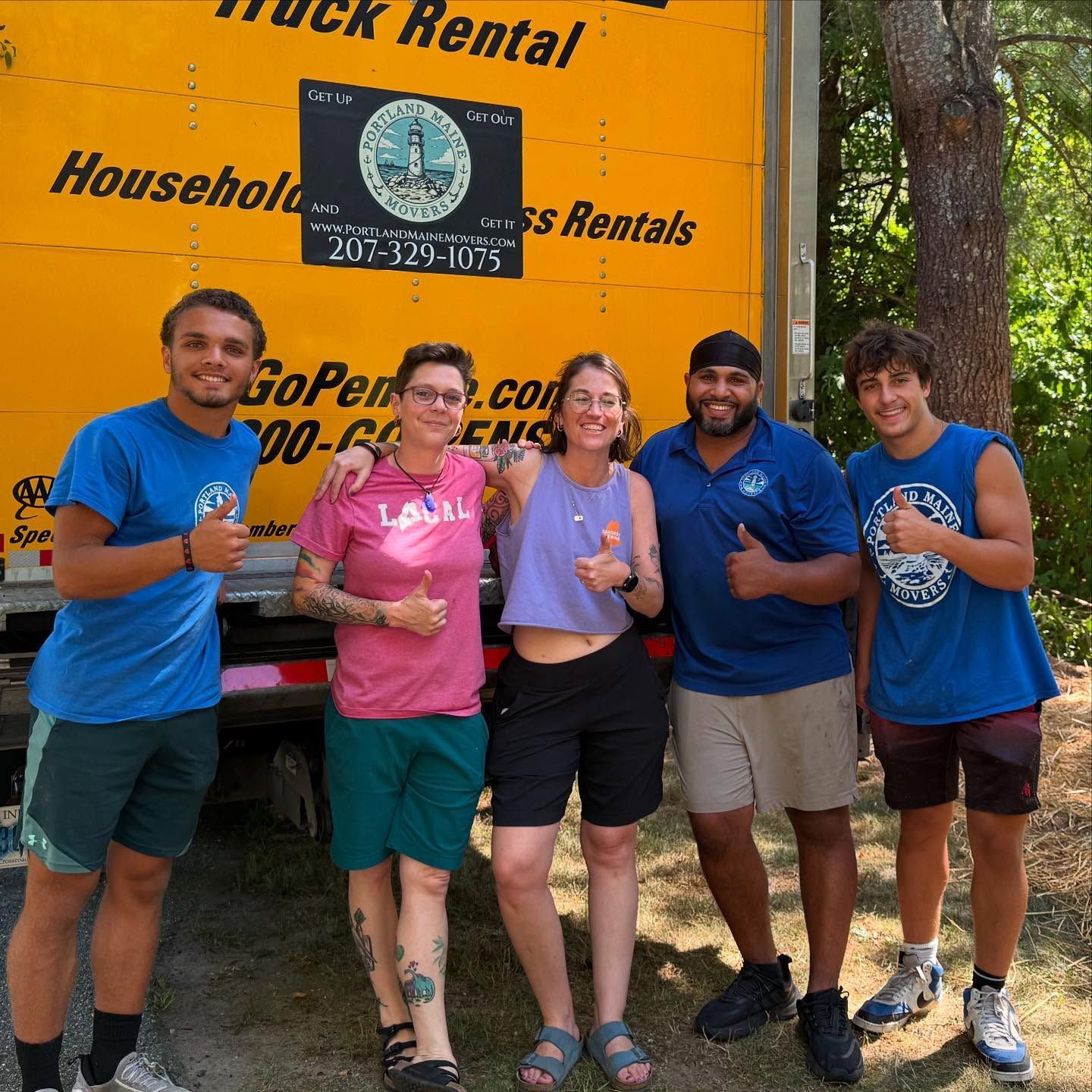 Five people giving thumbs-up next to a yellow moving truck.