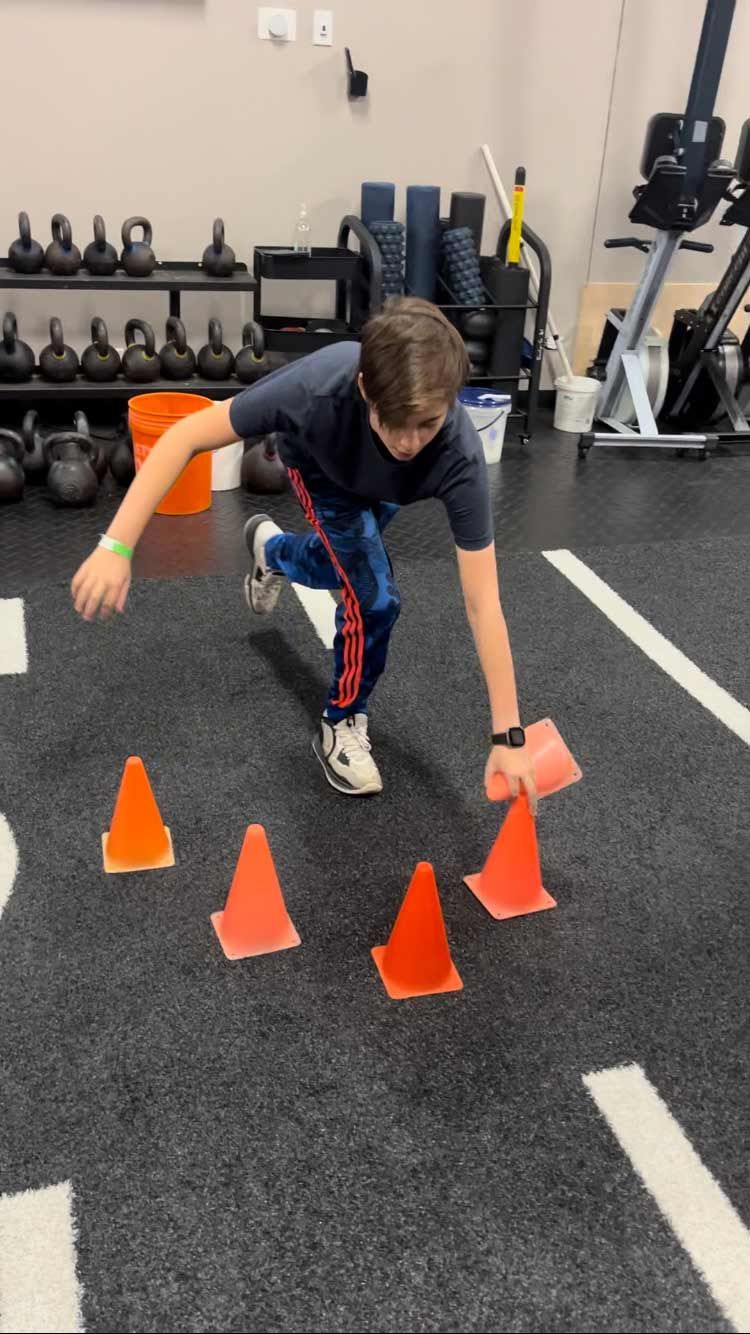 A Young Boy With Orange Cones In A Gym - Chicago, IL - Fast Track Physio