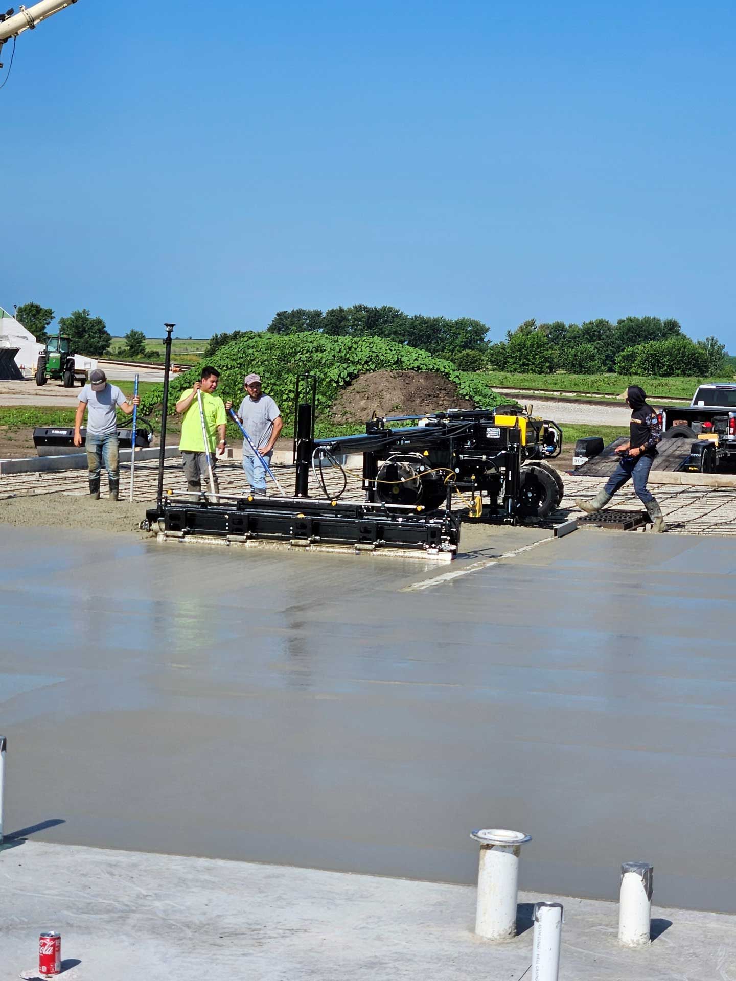 A group of construction workers are working on a concrete floor