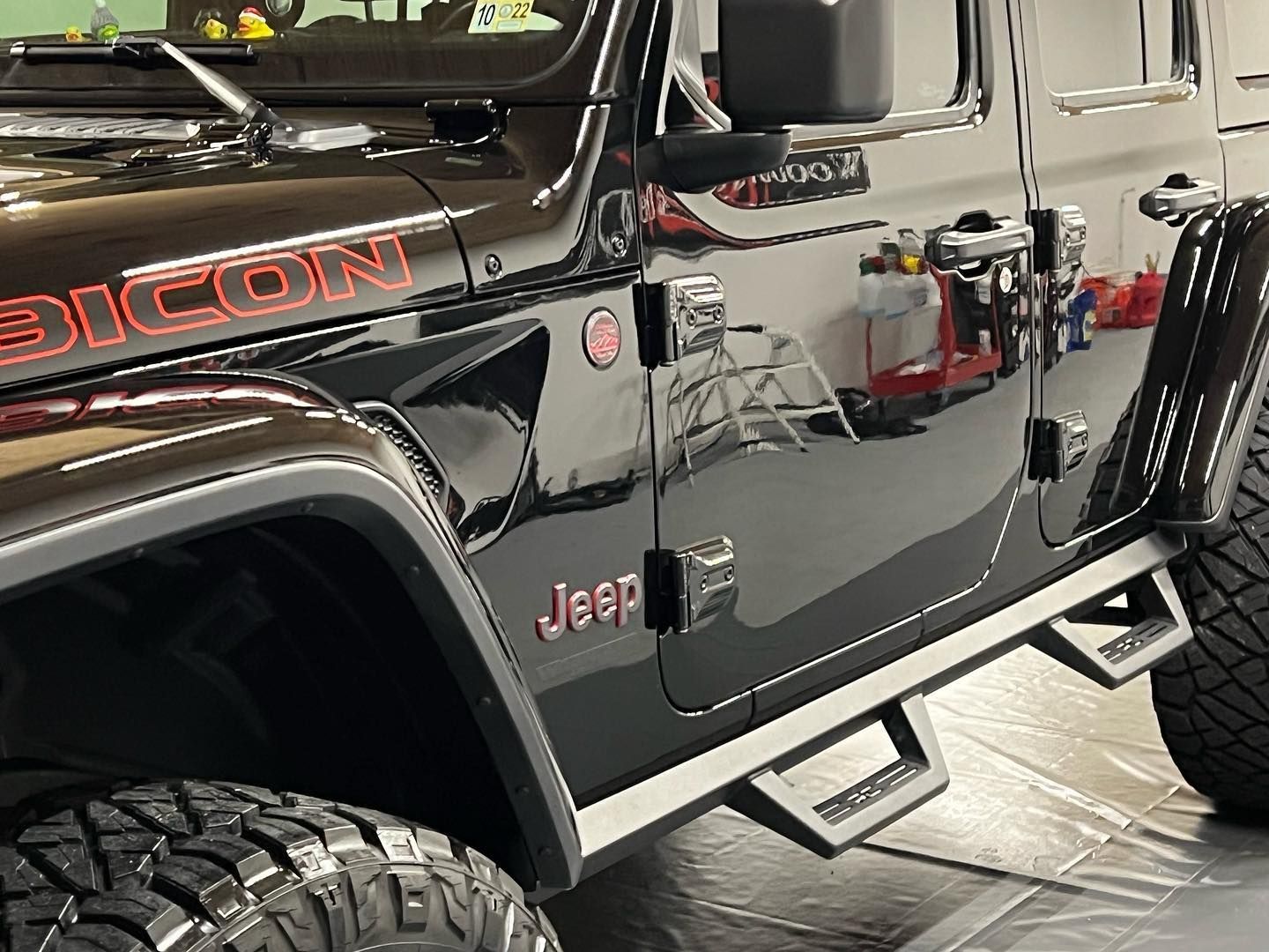 Black Jeep Rubicon with red lettering and side steps.
