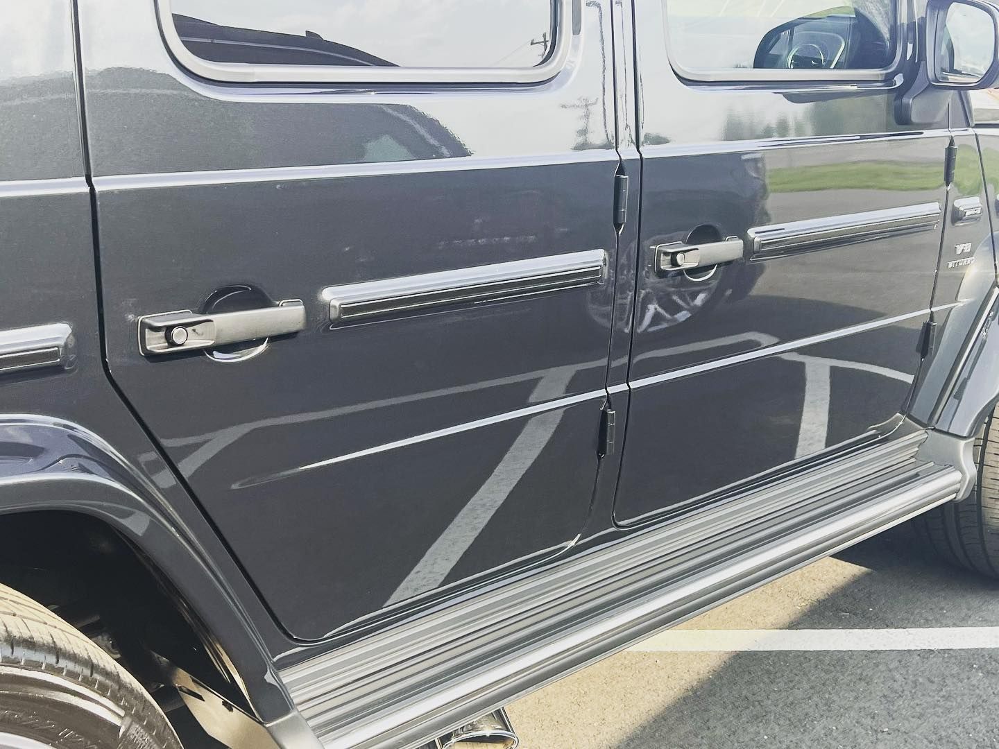 Black Mercedes-Benz SUV, side view. Features a running board and door handles, parked outdoors.