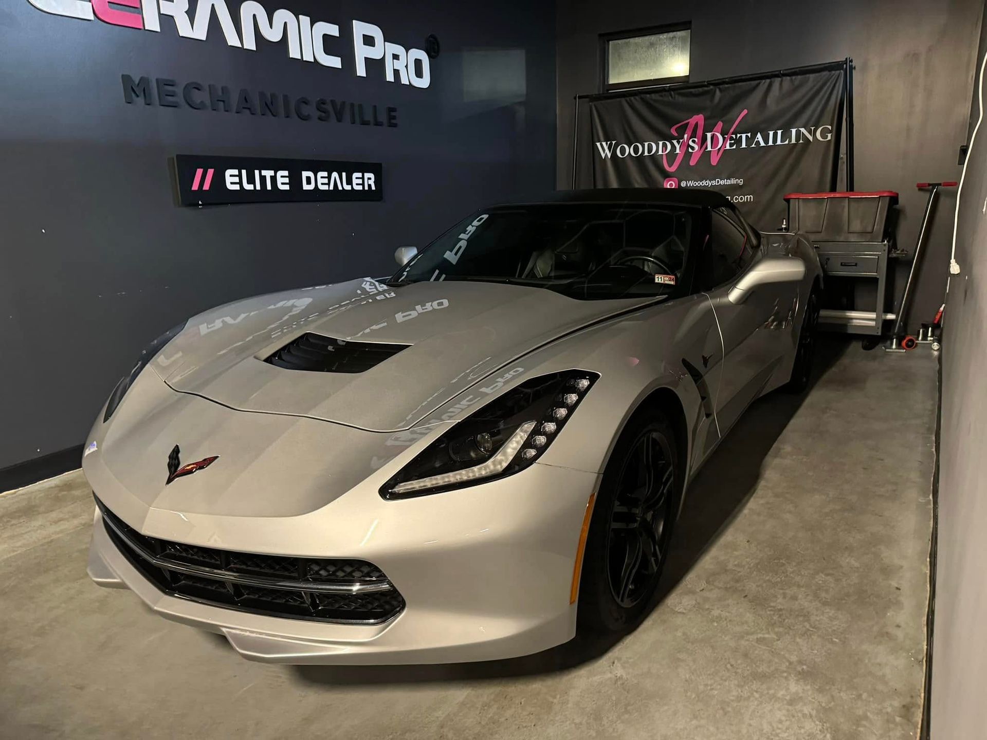 Silver Corvette sports car inside a Ceramic Pro Mechanicsville detailing shop.