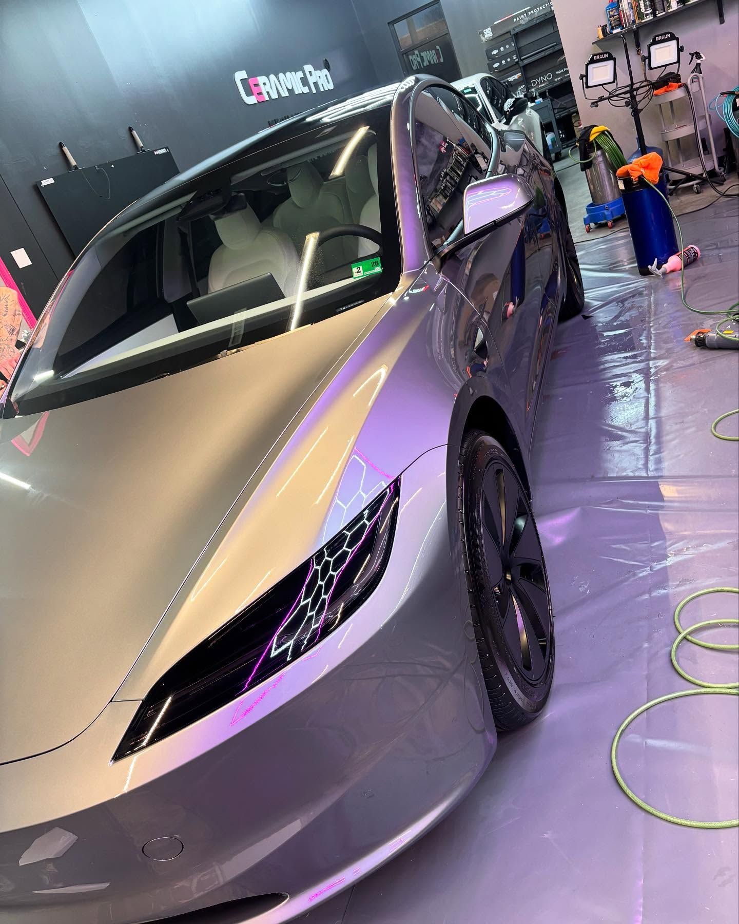 Silver Tesla electric car inside a shop.