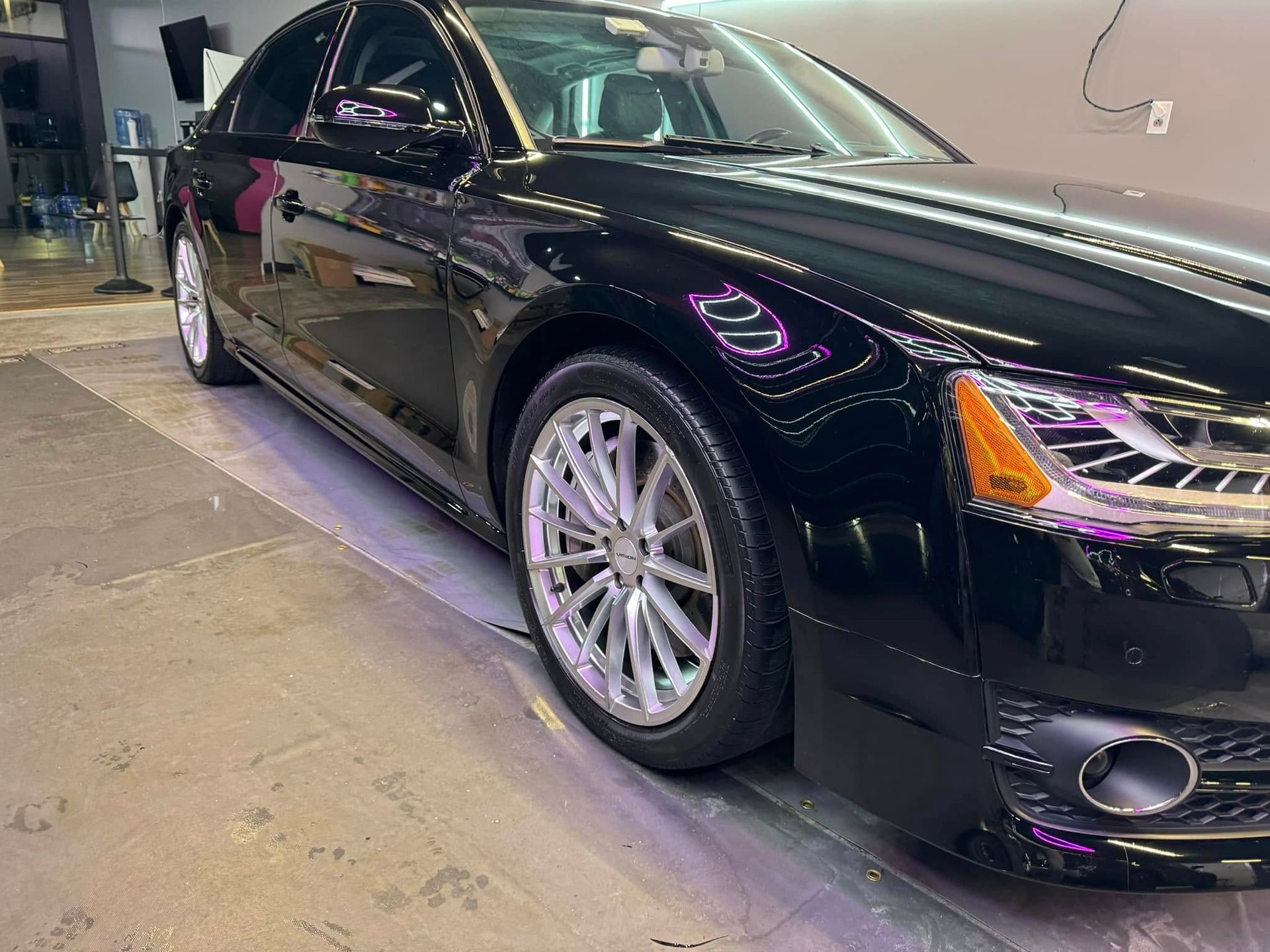 Black Audi sedan with silver rims parked inside a building.