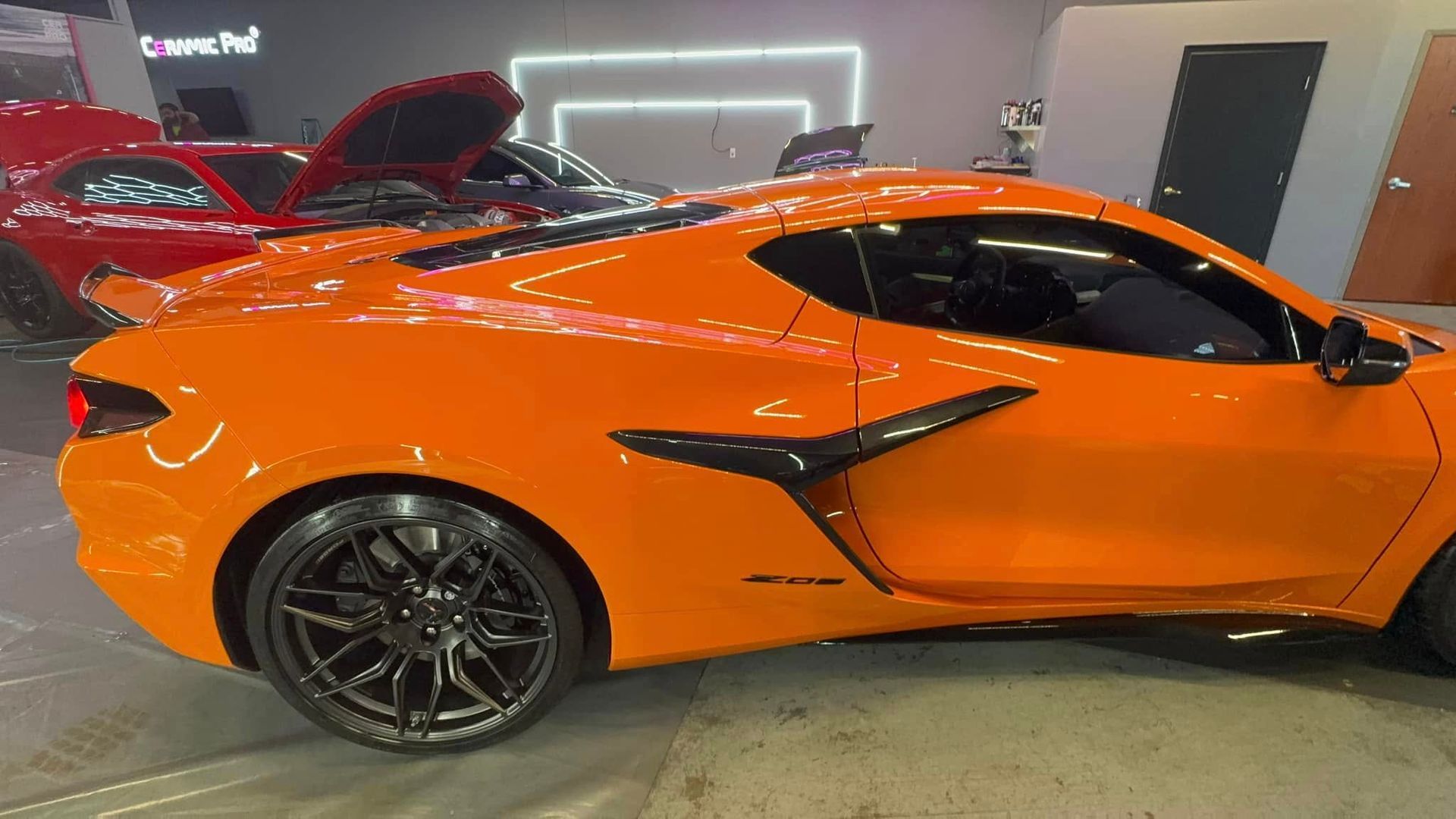 Orange sports car with black accents parked inside.