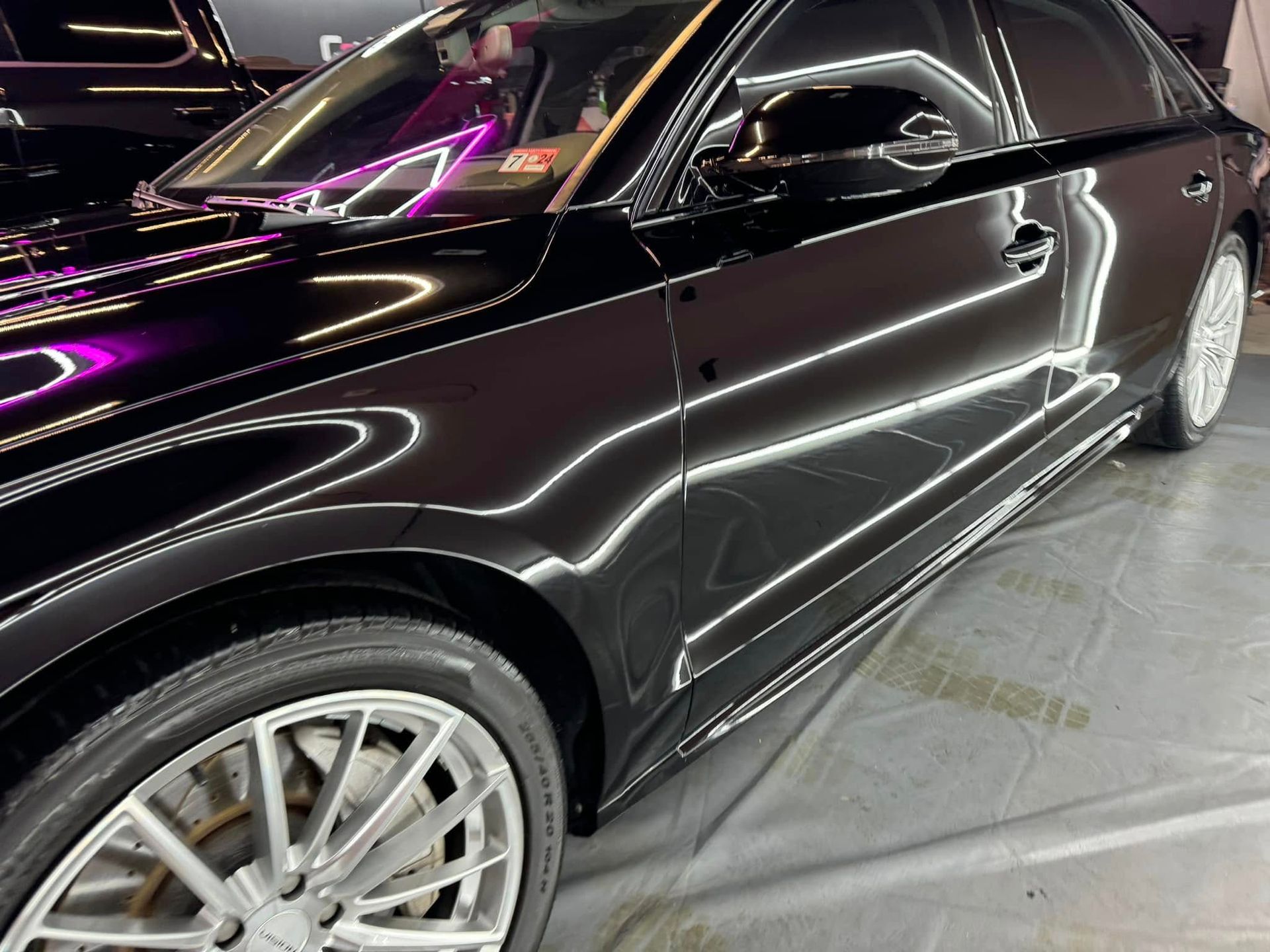 Black car with shiny finish and silver rims.