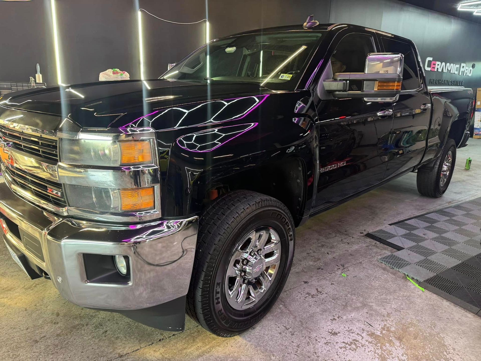 Black Chevrolet pickup truck in a well-lit garage, chrome accents visible.