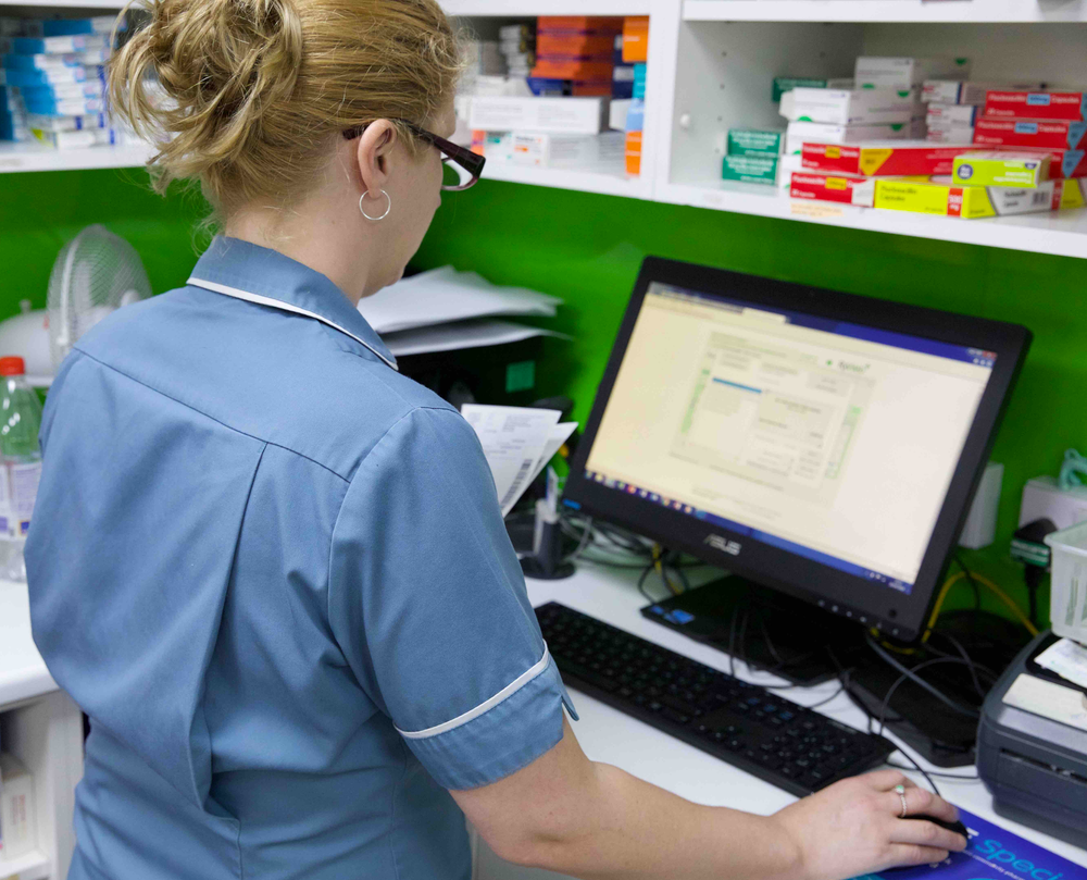 A woman is working on a computer in a pharmacy