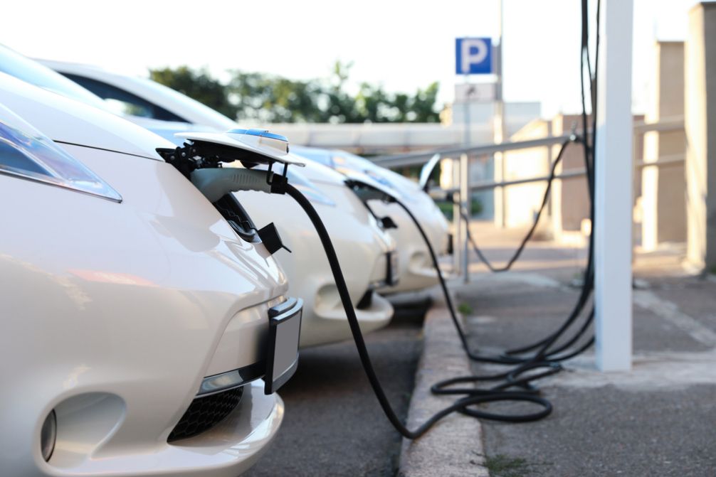 Row Of White Cars Are Being Charged At A Charging Station — Anthony Cameron Electrical & Solar in Kepnock, QLD