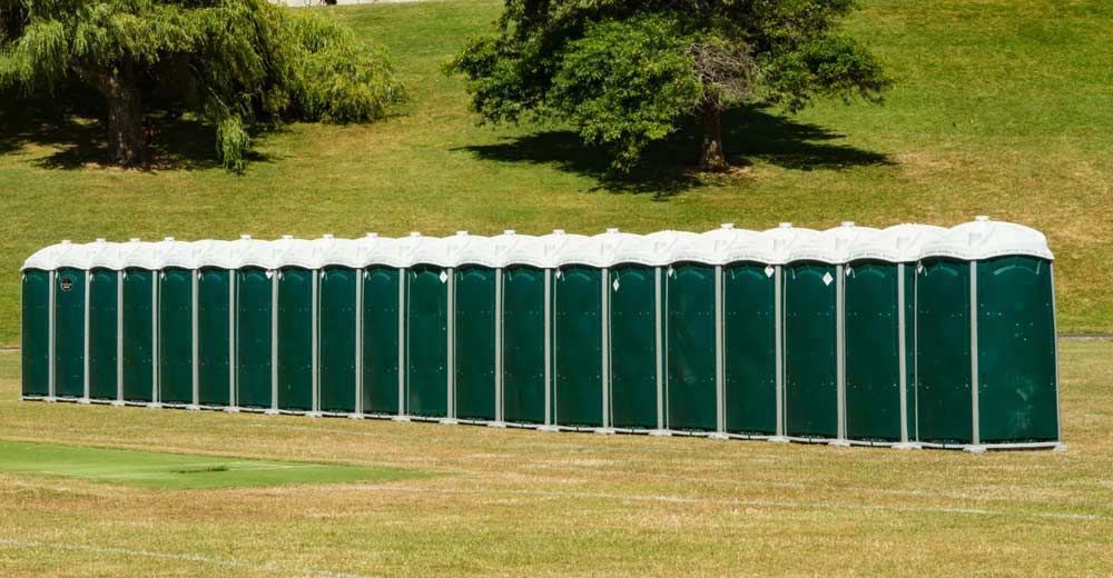Green Portaloos On An Open Space