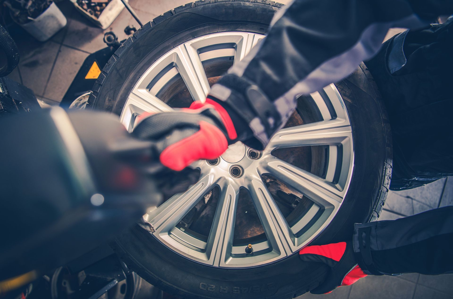 A person is changing a tire on a car with a wrench.