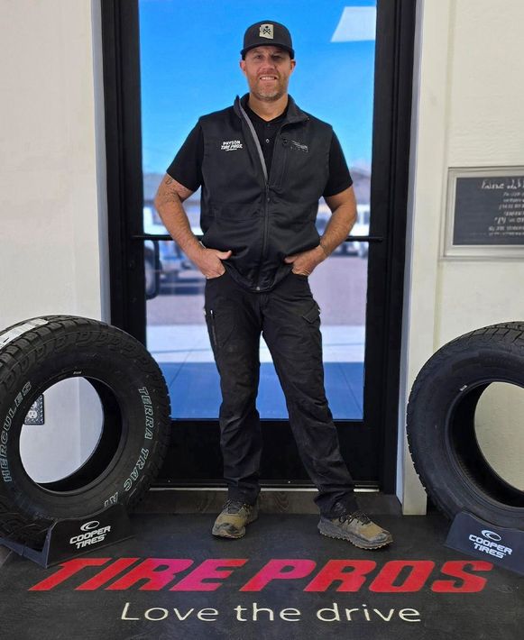 A man is standing in front of a tire shop.