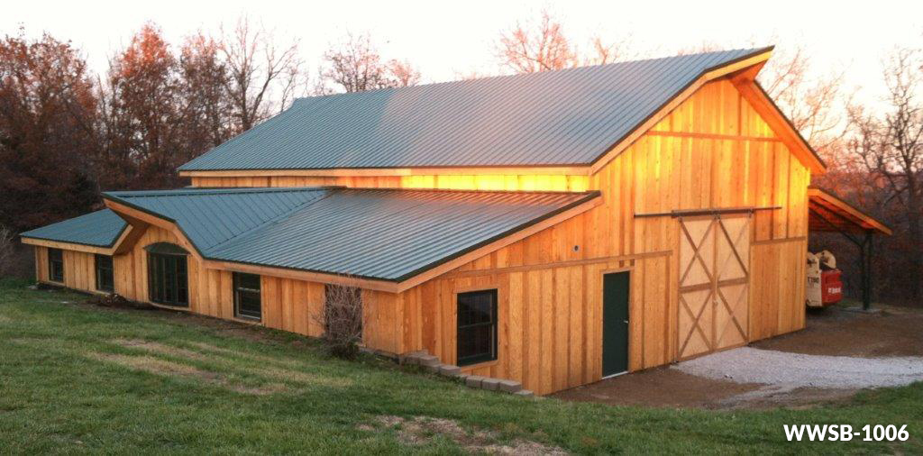 a large wooden barn with a green roof