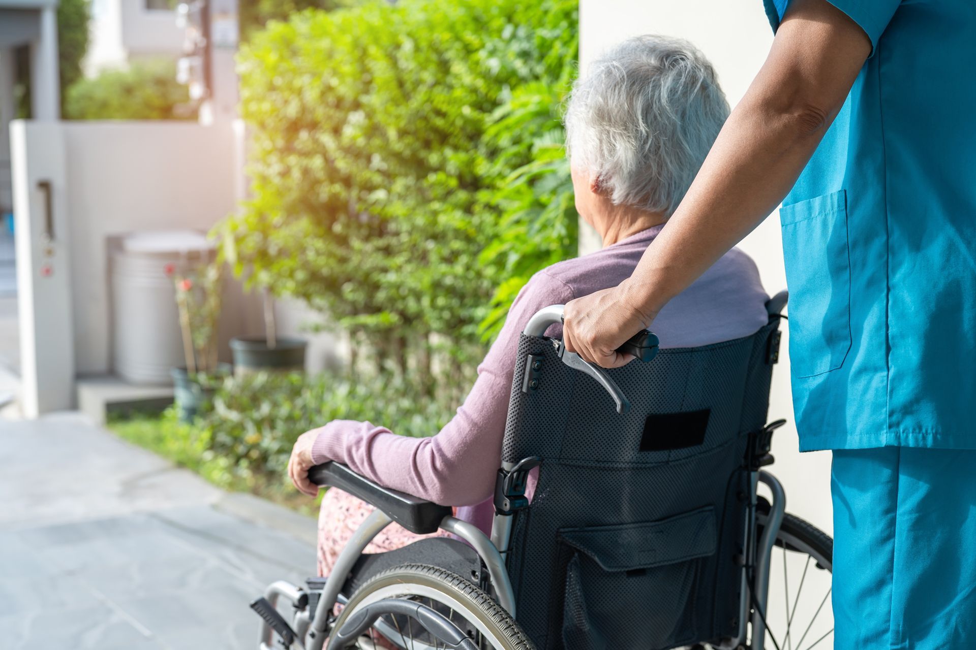 Nurse Assiting an Elderly Woman on Wheelchair
