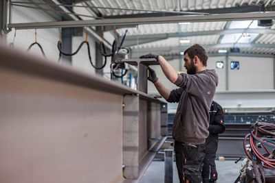 Ein Mann arbeitet in einer Fabrik an einer Metallkonstruktion. | FL Projektbau