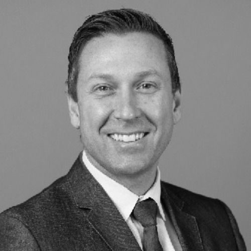 A dining room with a table and chairs and a wooden staircase.