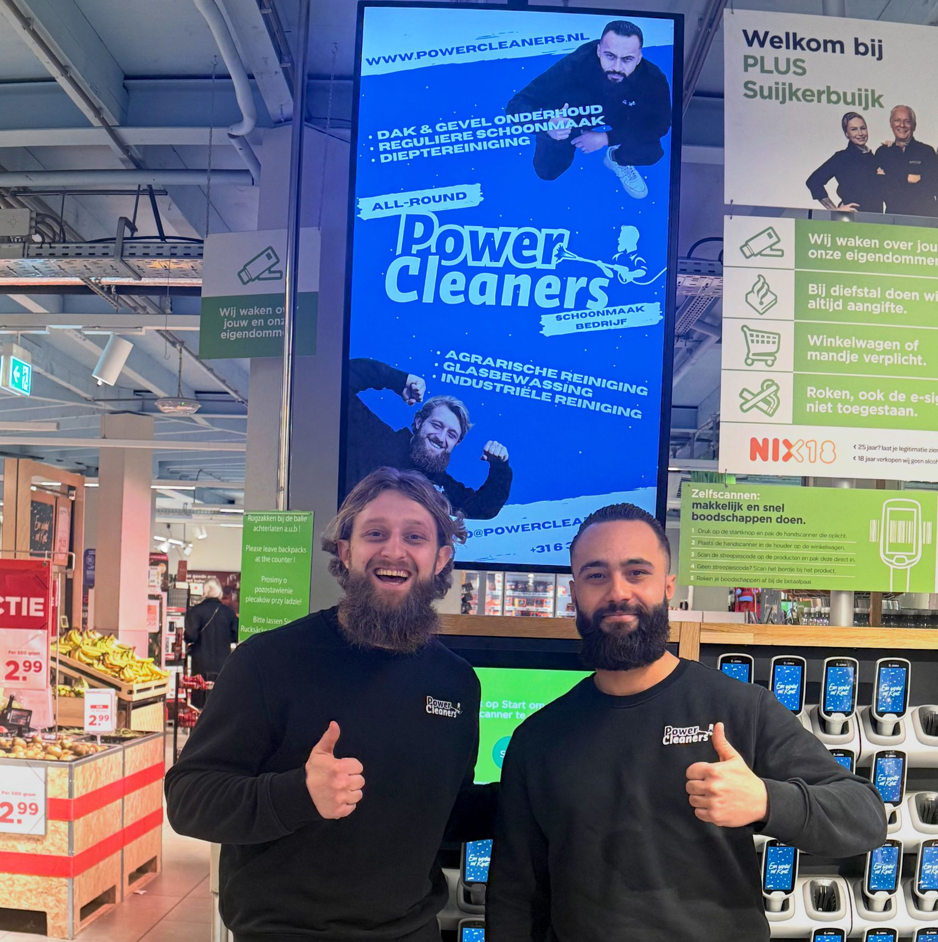 Twee mannen steken hun duim omhoog voor een blauwe reclame voor 