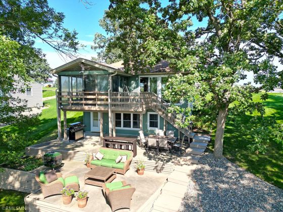 An aerial view of a house with a patio and trees in the background.