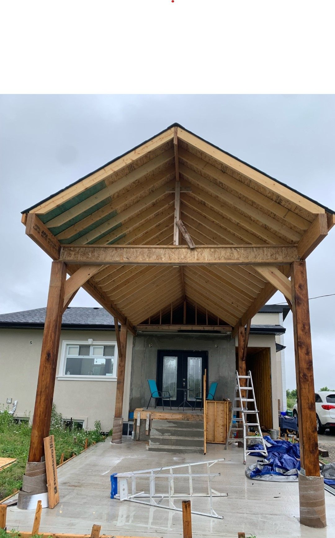 A wooden structure is being built in front of a house.