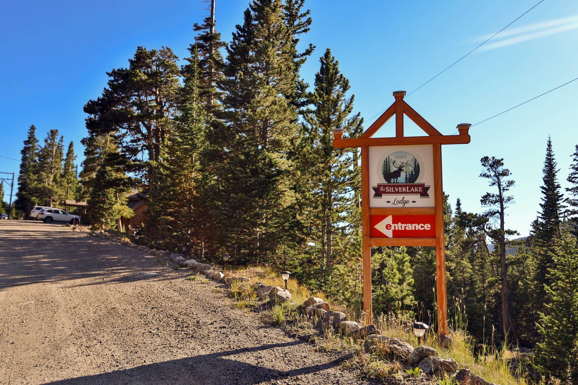 A sign on the side of a dirt road points to the right