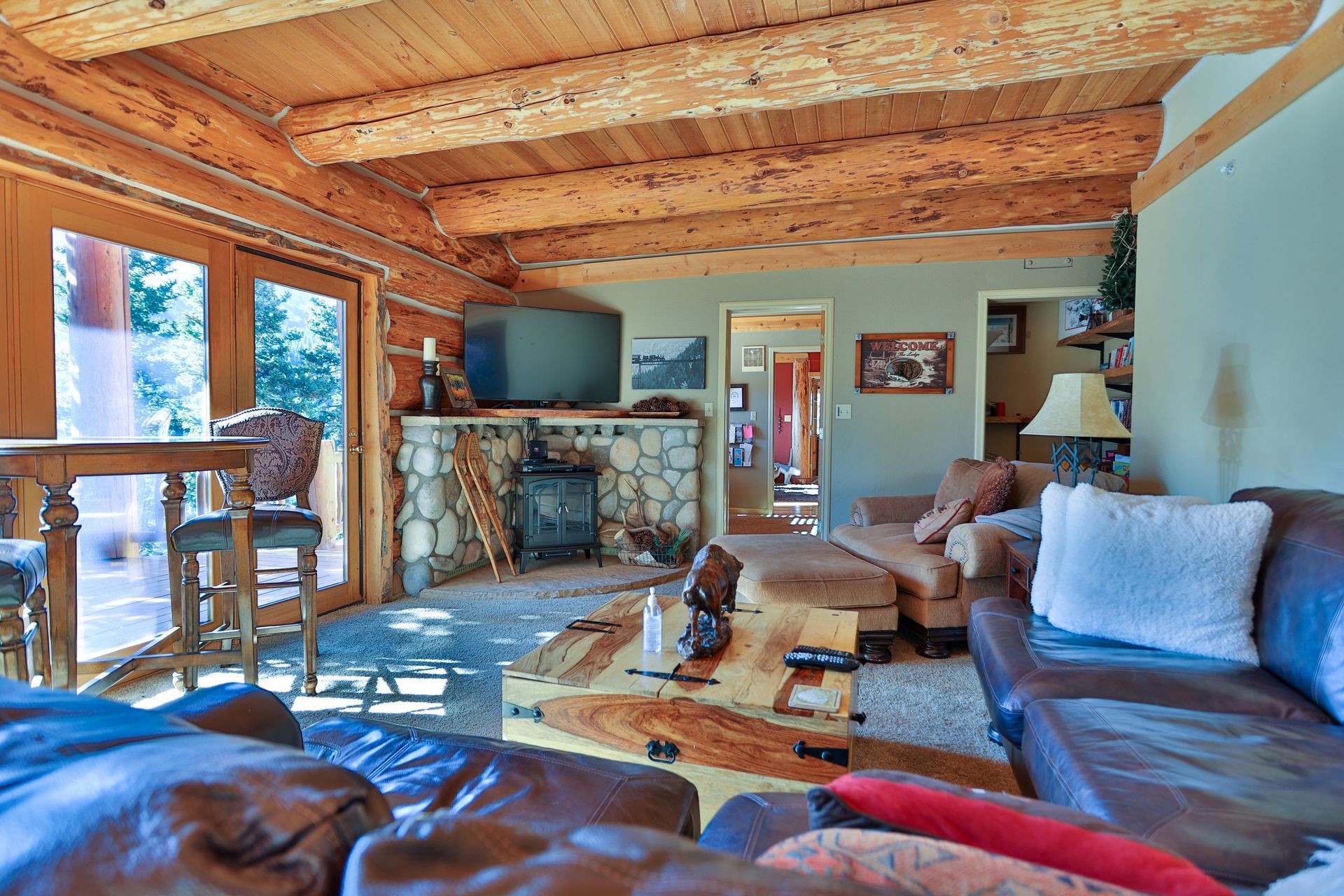 A living room filled with furniture and a fireplace in a log cabin.